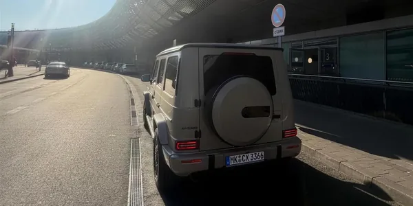 Unsere sandfarbene Mercedes G-Klasse von hinten auf einer Straße in der Morgendämmerung